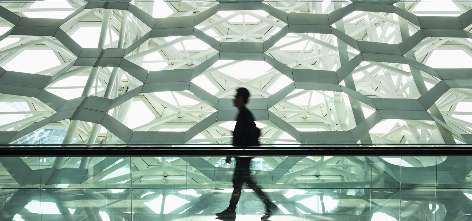 Man walking alone in modern corridor hallway