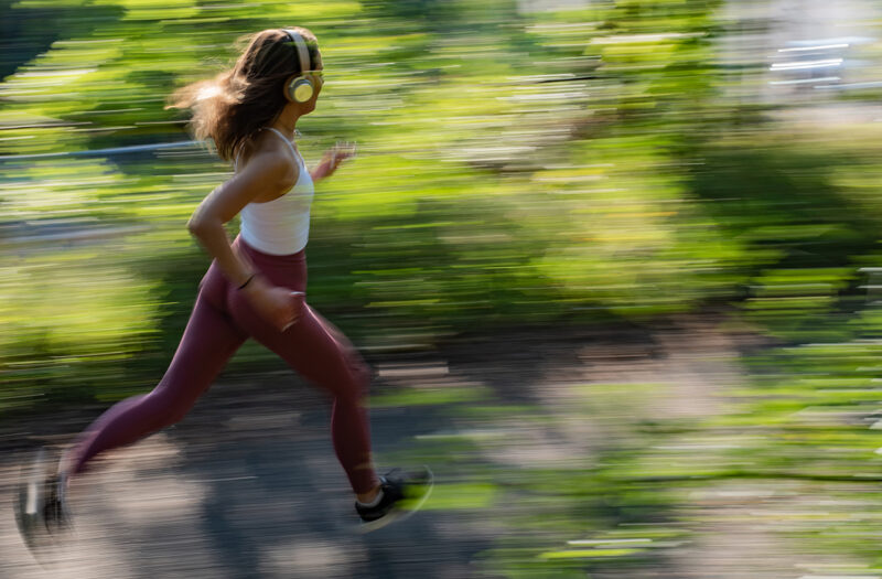 Young sporty woman jogging through the forest.
