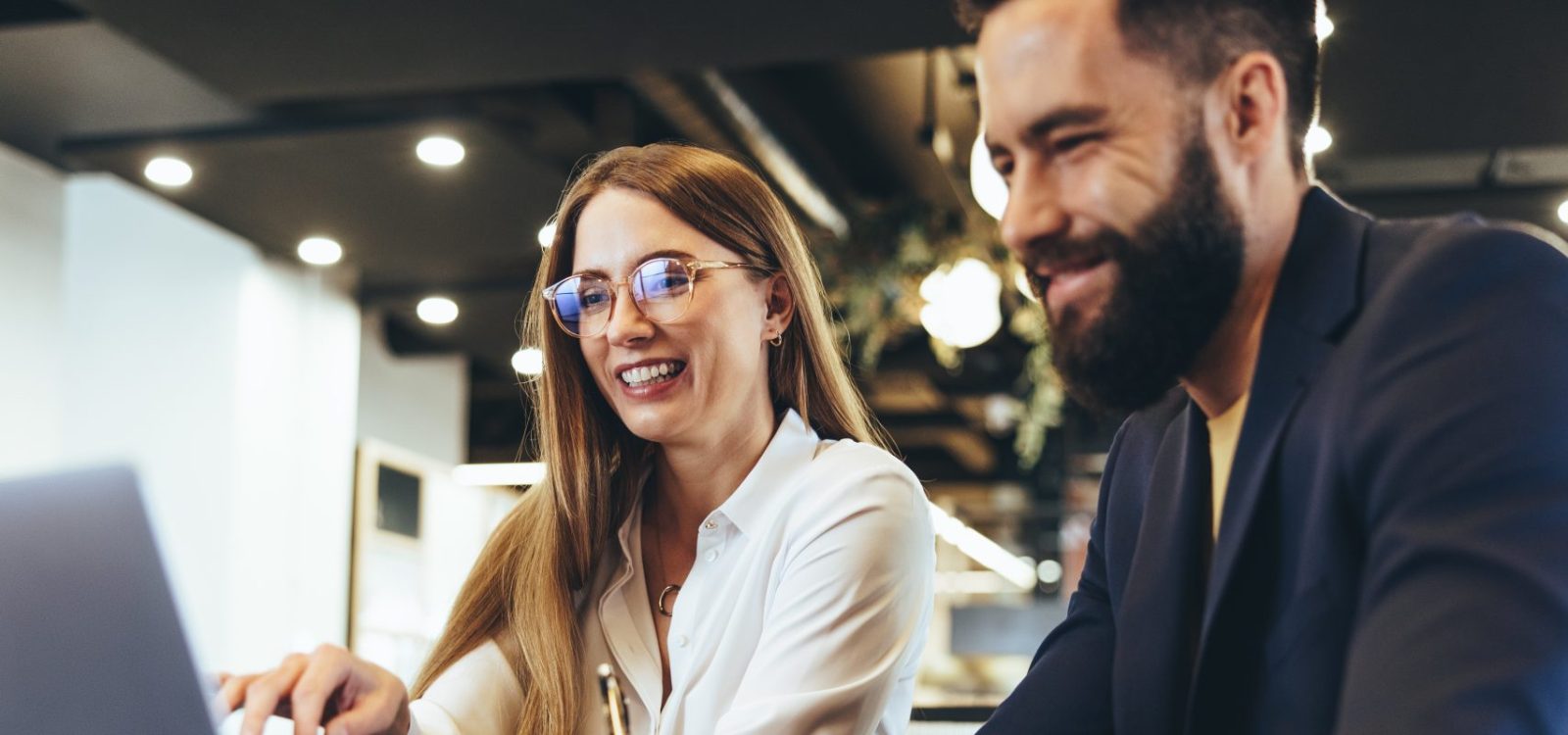Cheerful businesspeople using a laptop in an office