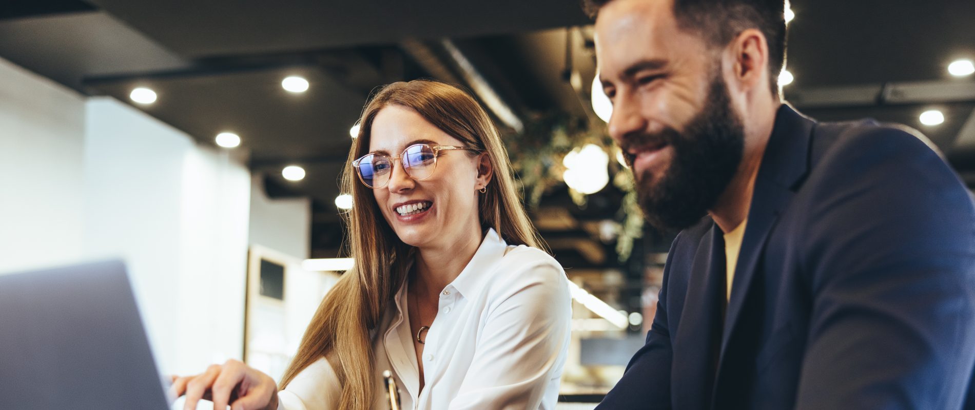 Cheerful businesspeople using a laptop in an office