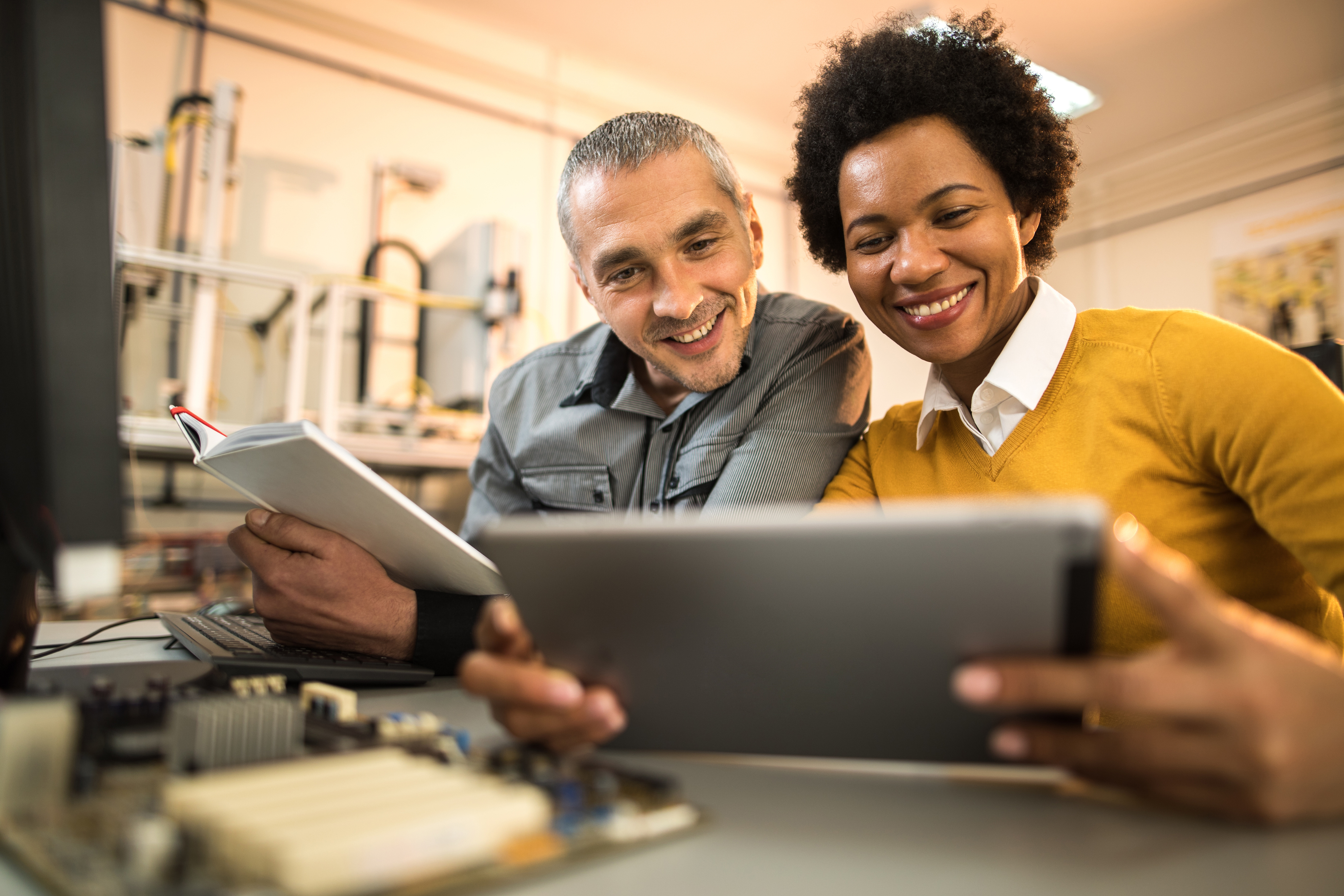 Happy scientists using digital tablet while working on a new tech project.