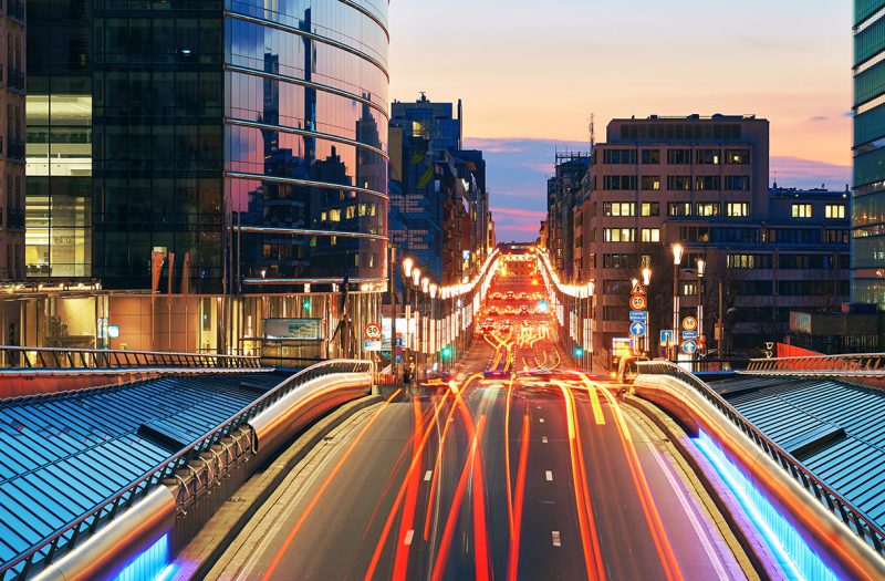 Long exposure shot of a downtown street at sunset. Skyscrapers on background with traffic lights. Brussels, Belgium.